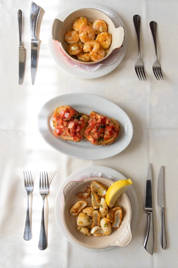 Tisch mit Bruschetta, Sepia und Crevetten — Restaurant Grotto Reale Zürich