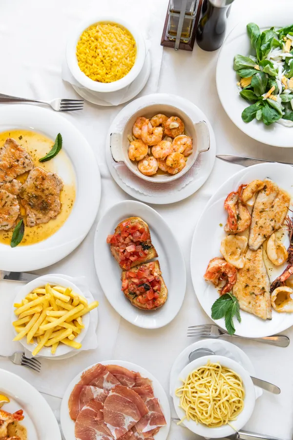 Tisch von oben mit Bruschetta, Crevetten und Fischteller — Grotto Reale Zürich